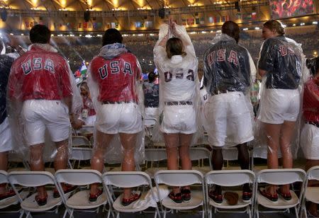 2016 Rio Olympics - Closing ceremony - Maracana - Rio de Janeiro, Brazil - 21/08/2016. U.S. athletes stand on chairs in the rain during the closing ceremony. REUTERS/Stoyan Nenov