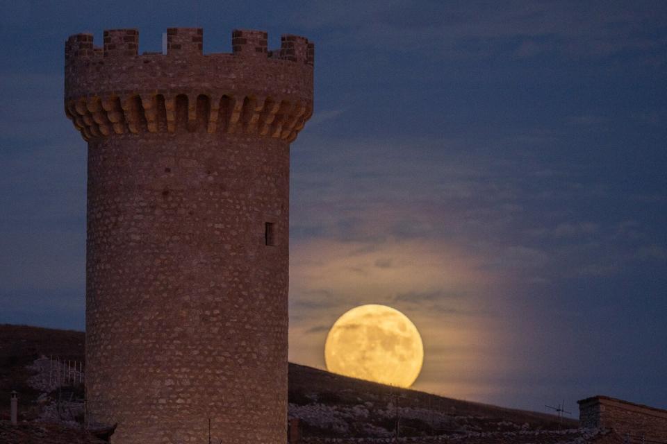 The Hunter's Moon rises at a size of 99.6 percent behind Torre Medicea medieval tower in Santo Stefano di Sessanio (AQ), Italy, on October 19, 2021.