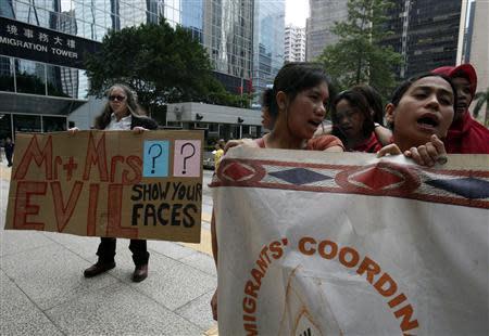 Domestic helpers and a demonstrator rally in support of an Indonesian maid who was tortured by her employers, outside Wanchai District Court in Hong Kong September 18, 2013. REUTERS/Bobby Yip