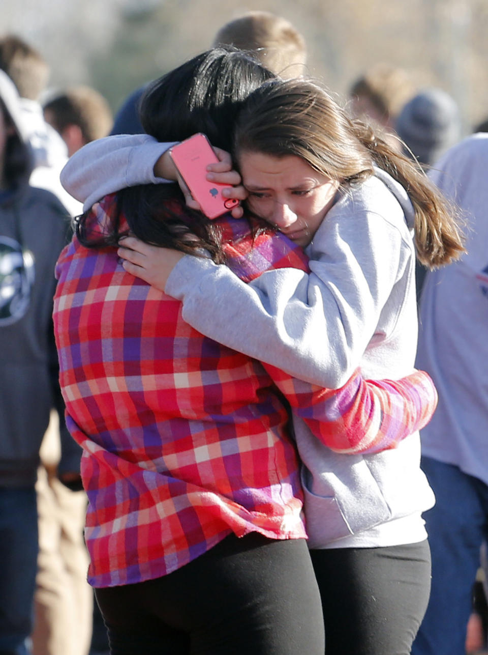 FILE - In this Dec. 13, 2013 file photo, students comfort each other outside of Arapahoe High School after a shooting on the campus in Centennial, Colo. Although still relatively rare, there’s been no real reduction in the number of school shootings since security was beefed up around the country with measures such as safety drills and the hiring of police officers, after the rampage at Connecticut's Sandy Hook Elementary School in December 2012. (AP Photo/Ed Andrieski)