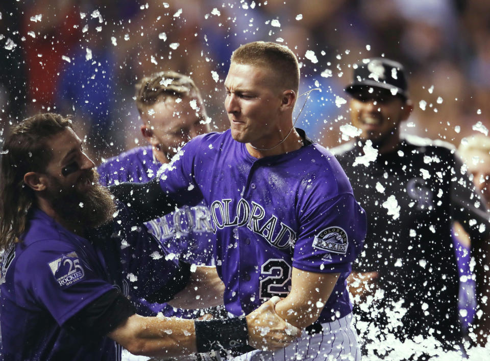 Colorado Rockies' Charlie Blackmon, left, congratulates Ryan McMahon for his three-run, walk-off home run off Los Angeles Dodgers relief pitcher JT Chargois during a baseball game Saturday, Aug. 11, 2018, in Denver. (AP Photo/David Zalubowski)