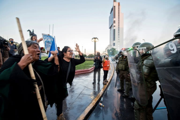 Mapuche indigenous demonstrators and human rights activists protest in front of riot police over the death of a young Mapuche man in Santiago, on November 15, 2018