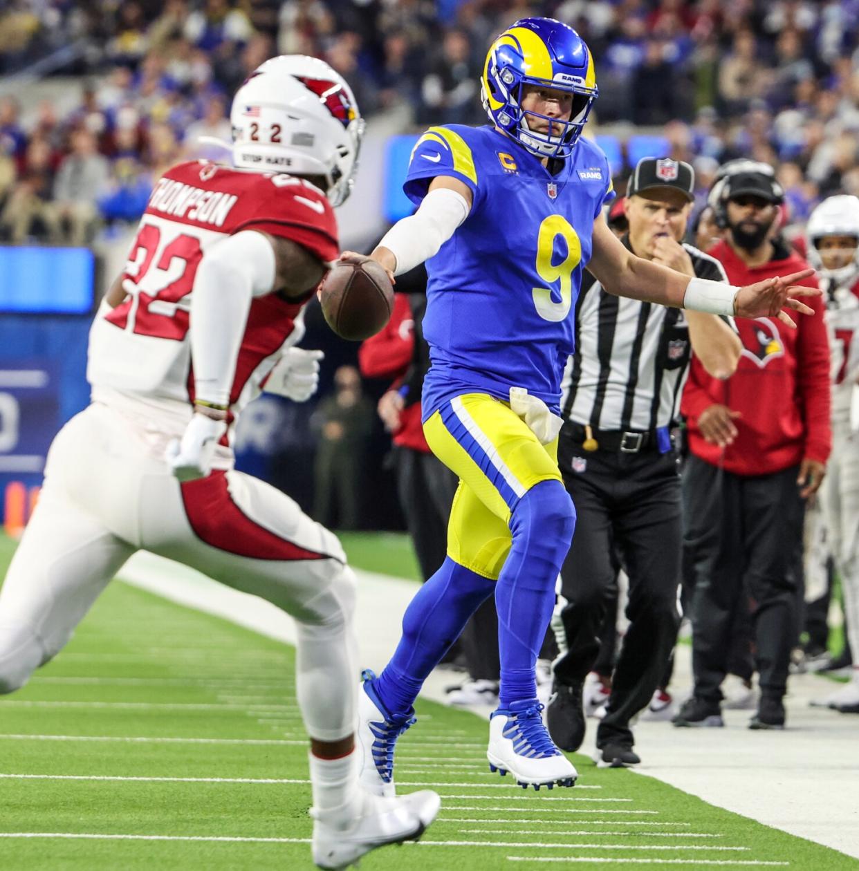 Rams quarterback Matthew Stafford stretches for extra yardage on a third-quarter run as Arizona's Deionte Thompson pursues.