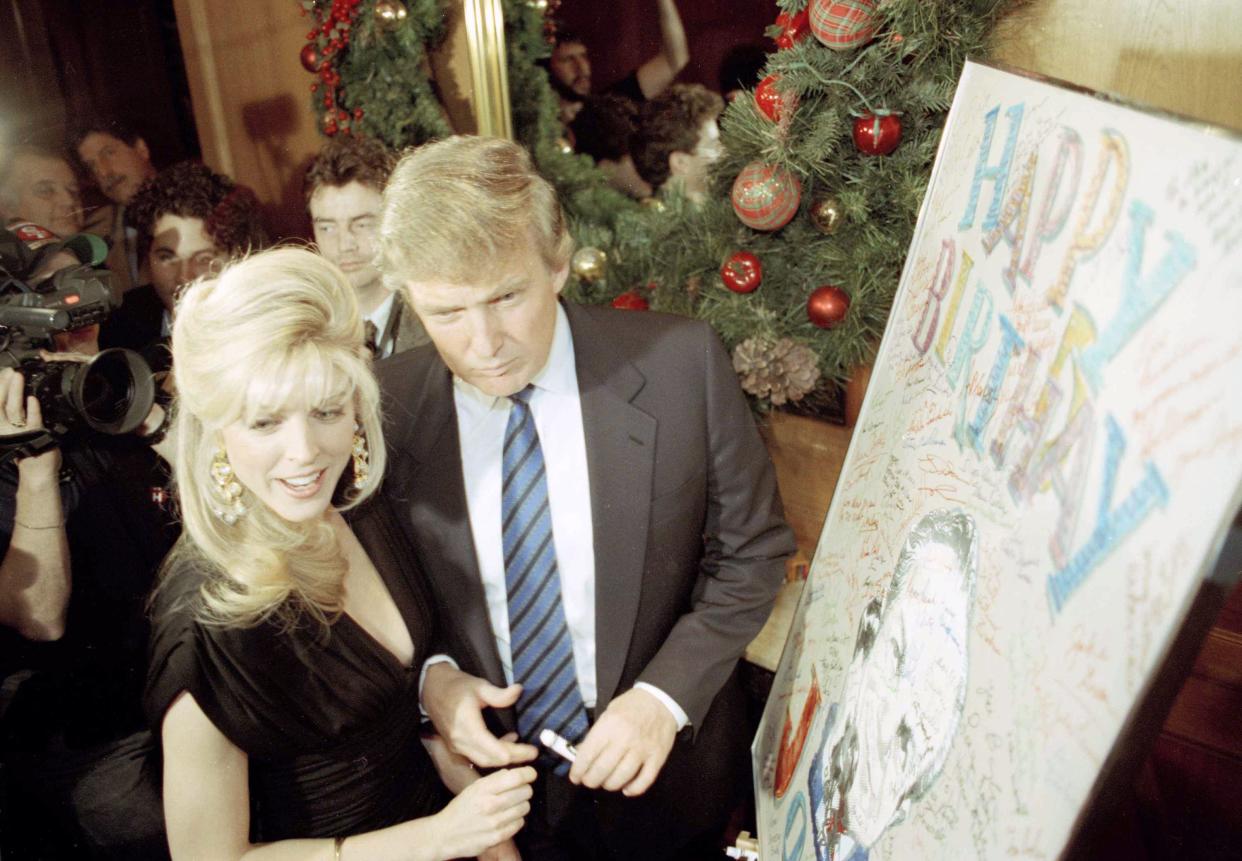 Donald Trump and Marla Maples sign Joey Adam's birthday card at the Helmsley Hotel in New York where his 80th birthday bash was held in New York, on Jan. 7, 1991.