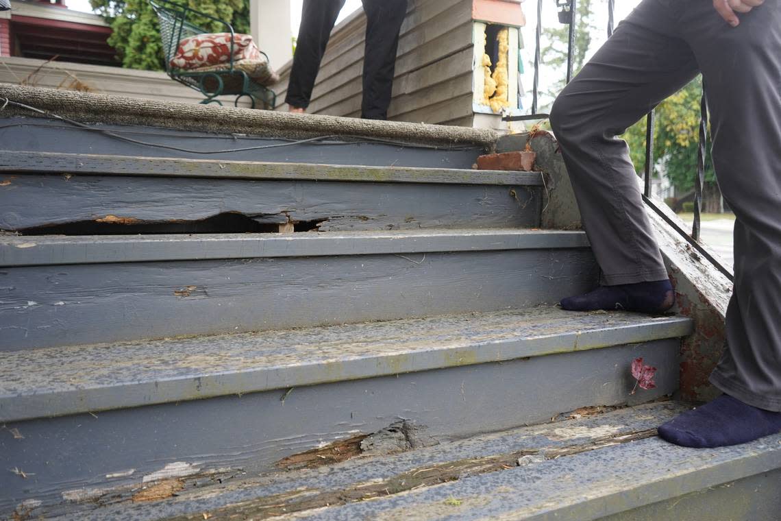 Aidan Hersh stands outside on the broken porch stairs at 1210 Ellis Street on Sept. 27, 2023, in Bellingham, Wash. Holes are visible in the wood.