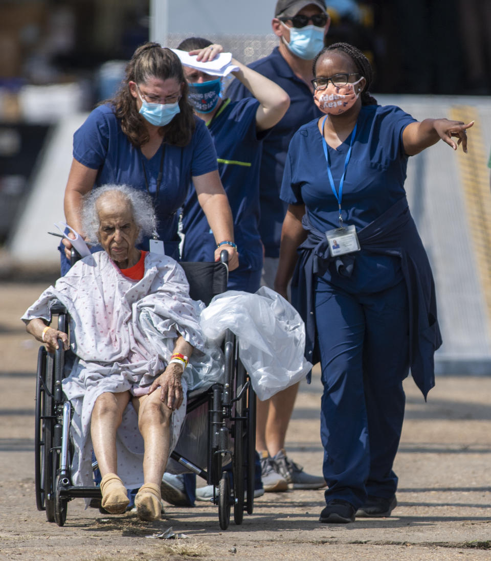 Paramedics evacuate people at a mass shelter Thursday, Sep.t 2, 2021 in Independence, La. Multiple nursing home residents died after Hurricane Ida, but full details of their deaths are unknown because state health inspectors said Thursday that they were turned away from examining conditions at the facility to which they had been evacuated. (Chris Granger/The Times-Picayune/The New Orleans Advocate via AP)