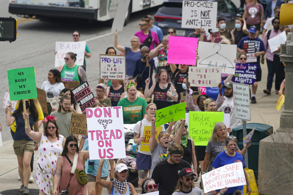 Abortion-rights protestors march between the Indiana Statehouse and the Indiana State Library where Vice President Kamala Harris was meeting with Indiana legislators to discuss reproductive right in Indianapolis, Monday, July 25, 2022. The Indiana legislature is starting a special legislative session to address new abortion laws and refunds to residents from the states budget surplus. (AP Photo/Michael Conroy)