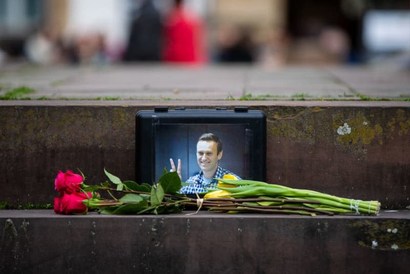Flowers lie in front of a picture of leading Russian opposition figure Alexei Navalny, who died in prison while serving a 19-year sentence, during a prayer service at Schillerplatz in Stuttgart. Christoph Schmidt/dpa