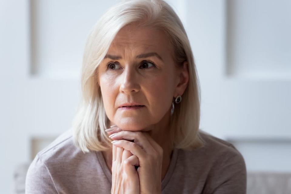 Mature woman sitting upset at home.