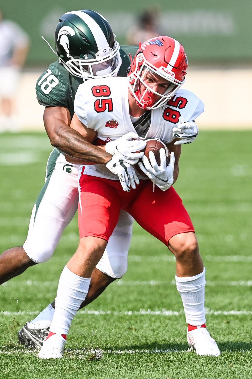 Michigan State's Kalon Gervin, left, tackles Youngstown State's Luke Hensley during the fourth quarter on Saturday, Sept. 11, 2021, at Spartan Stadium in East Lansing.