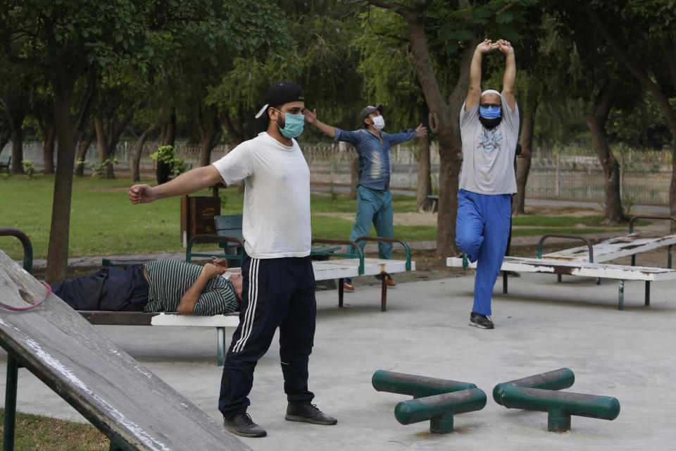 People exercise in a park in Lahore, Pakistan, Friday, June 5, 2020. Government of Pakistan's Punjab province has reopened parks in different cities of the province including Lahore amid coronavirus outbreak. (AP Photo/K.M. Chaudary)