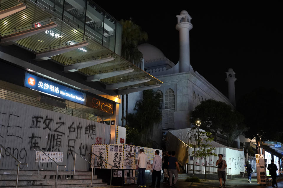 People walk past a mosque next to a subway station at a main road in Hong Kong Sunday, Oct. 20, 2019, Hong Kong. A water cannon truck and armored car led a column of dozens of police vans up and down Nathan Road, a major artery lined with shops, to spray a stinging blue-dyed liquid as police moved to clear the road of protesters and barricades.(AP Photo/Vincent Yu)