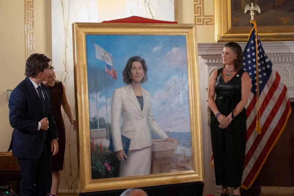 Artist Patricia Watwood, right, and former Gov. Gina Raimondo's children, Thompson and Cecilia, at Thursday's unveiling of Raimondo's official portrait at the State House.  Watwood said Raimondo's white suit was a nod to women's suffrage.