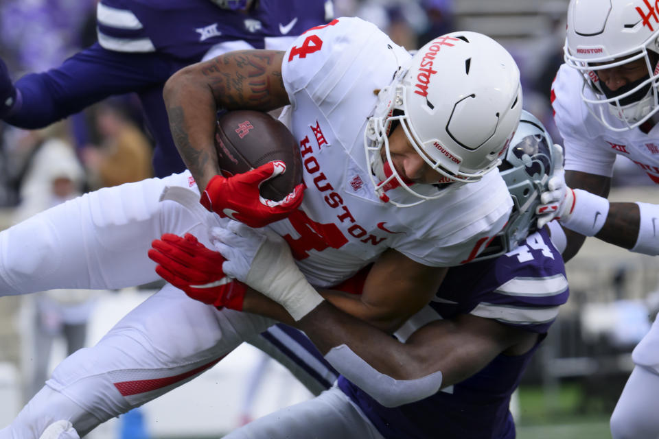 Houston wide receiver Jonah Wilson (14) is tackled by Kansas State linebacker Tobi Osunsanmi (44) during the second half of an NCAA college football game in Manhattan, Kan., Saturday, Oct. 28, 2023. (AP Photo/Reed Hoffmann)