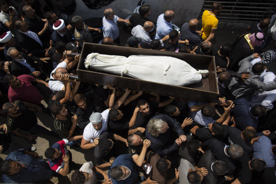 Relatives and friends of Hassan Zaher Ghosn, 14, who was killed last night, carry his coffin as they chant slogans during his funeral procession, in Khaldeh, south of Beirut, Lebanon, Friday, Aug. 28, 2020. Clashes broke out last night between rival groups at the southern entrance of the Lebanese capital leaving two people dead and three wounded, state-run National News Agency reported. (AP Photo/Hassan Ammar)