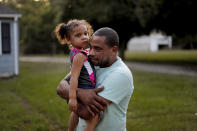 Jose Perez-Santiago, right, holds his daughter Jordalis, 2, as they return to their home for the first time since it was flooded in the aftermath of Hurricane Florence in Spring Lake, N.C., Wednesday, Sept. 19, 2018. "I didn't realize we would lose everything," said Perez-Santiago. "We'll just have to start from the bottom again." (AP Photo/David Goldman)