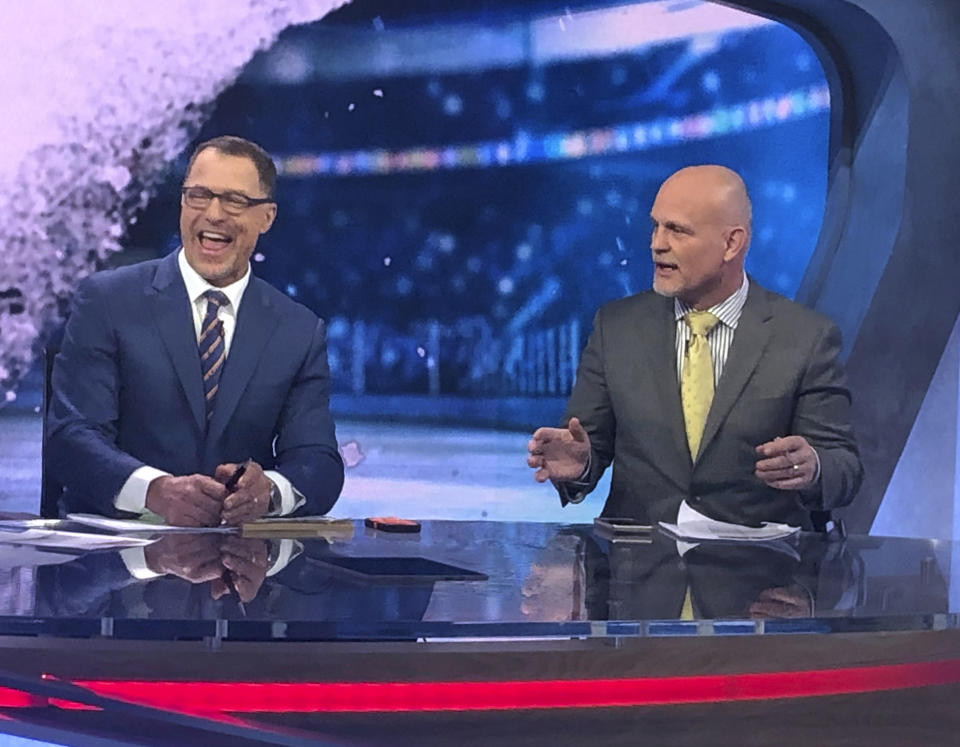 Former New Jersey Devils defensemen Scott Stevens, left, and Ken Daneyko appear on the set of NHL Network in Secaucus, N.J., Monday, April 29, 2019. After teaming up to help the New Jersey Devils win the Stanley Cup three times, retired defensemen Scott Stevens and Ken Daneyko are back together on the other side of the camera doing TV at NHL Network. (AP Photo/Stephen Whyno)