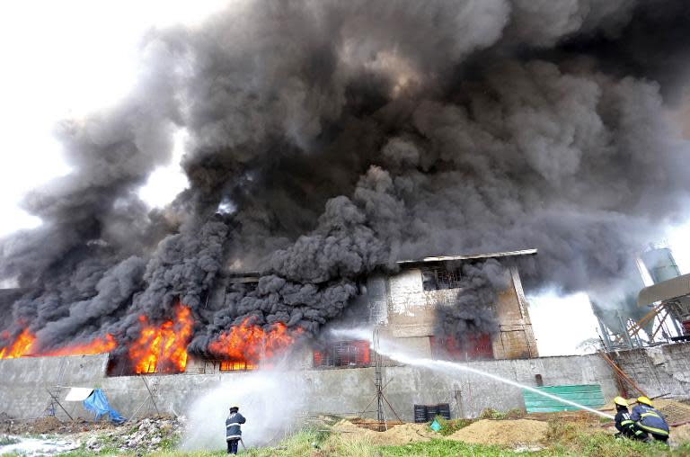 Philippines firemen try to put out a fire as it gutted a footwear factory in Valenzuela City, suburban Manila, on May 13, 2015