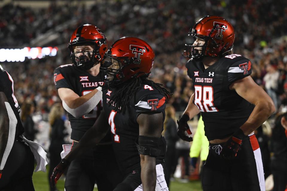 Texas Tech running back SaRodorick Thompson (4) reacts to a touchdown with wide receiver Coy Eakin, left, and tight end Baylor Cupp (88) against Kansas during the first half of an NCAA college football game, Saturday, Nov. 12, 2022, in Lubbock, Texas. (AP Photo/Justin Rex)