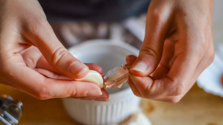 Hands peeling garlic