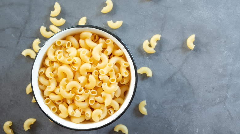 Raw macaroni on wooden background