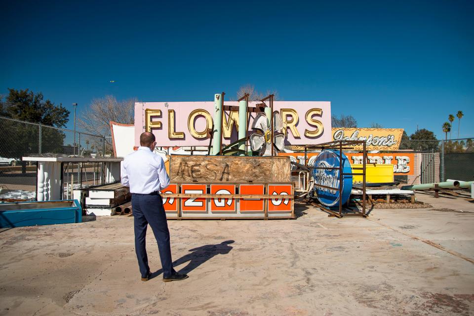 Jeff McVay, Mesa's downtown transformation manager, stands in front of a collection of the city's iconic neon signs that are sitting in a storage facility on Feb. 8, 2022.