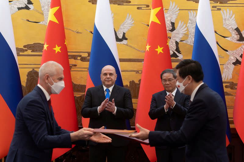 Russian Prime Minister Mikhail Mishustin and Chinese Premier Li Qiang attend a signing ceremony in Beijing