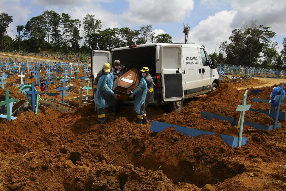 Cemetery workers carry the remains of 89-year-old Abilio Ribeiro, who died of the new coronavirus, to bury at the Nossa Senhora Aparecida cemetery in Manaus, Amazonas state, Brazil, Wednesday, Jan. 6, 2021. Manaus declared on Jan. 5 a 180-day state of emergency due to a surge of new cases of coronavirus. (AP Photo/Edmar Barros)