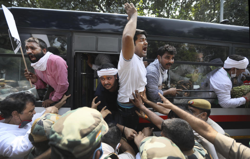 Member of India's opposition Congress party shout slogans as they are detained during a protest against agriculture bills in New Delhi, India, Monday, Sept. 21, 2020. Amid an uproar in Parliament, Indian lawmakers on Sunday approved a pair of controversial agriculture bills that the government says will boost growth in the farming sector through private investments. (AP Photo/Manish Swarup)