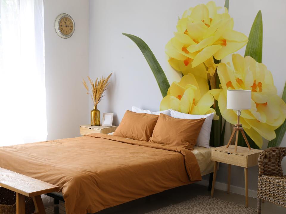 Bedroom with orange bed and yellow floral mural