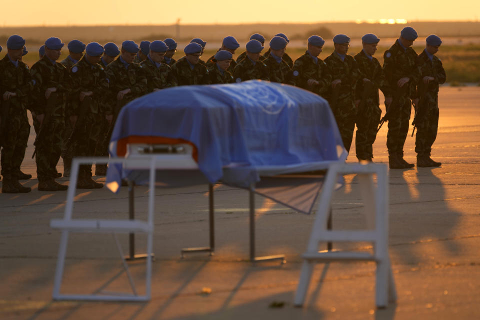 Irish and other U.N peacekeepers, stand near to the coffin draped by the United Nations flag of their comrade Pvt. Seán Rooney of Newtowncunningham who was killed during a confrontation with residents near the southern town of Al-Aqbiya on Wednesday night, during his memorial procession at the Lebanese army airbase, at Beirut airport, Sunday, Dec. 18, 2022. (AP Photo/Hussein Malla)