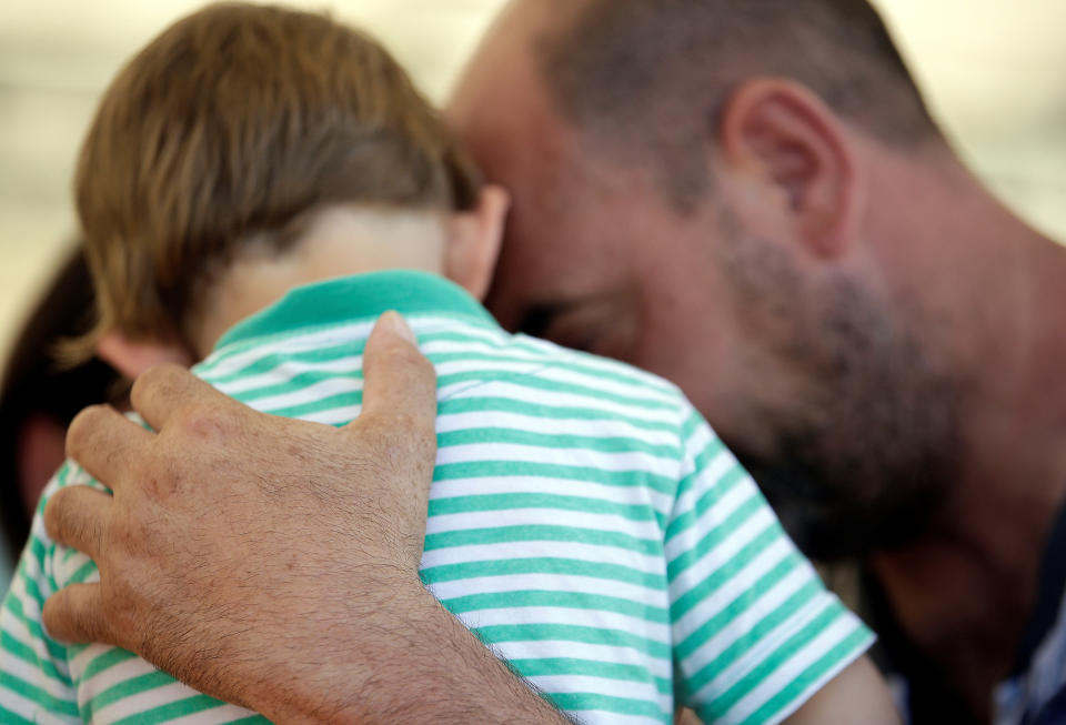 <p>A man embraces his son in a tent camp set up as temporary shelter following an earthquake in Pescara del Tronto, central Italy, August 26, 2016. (REUTERS/Max Rossi) </p>