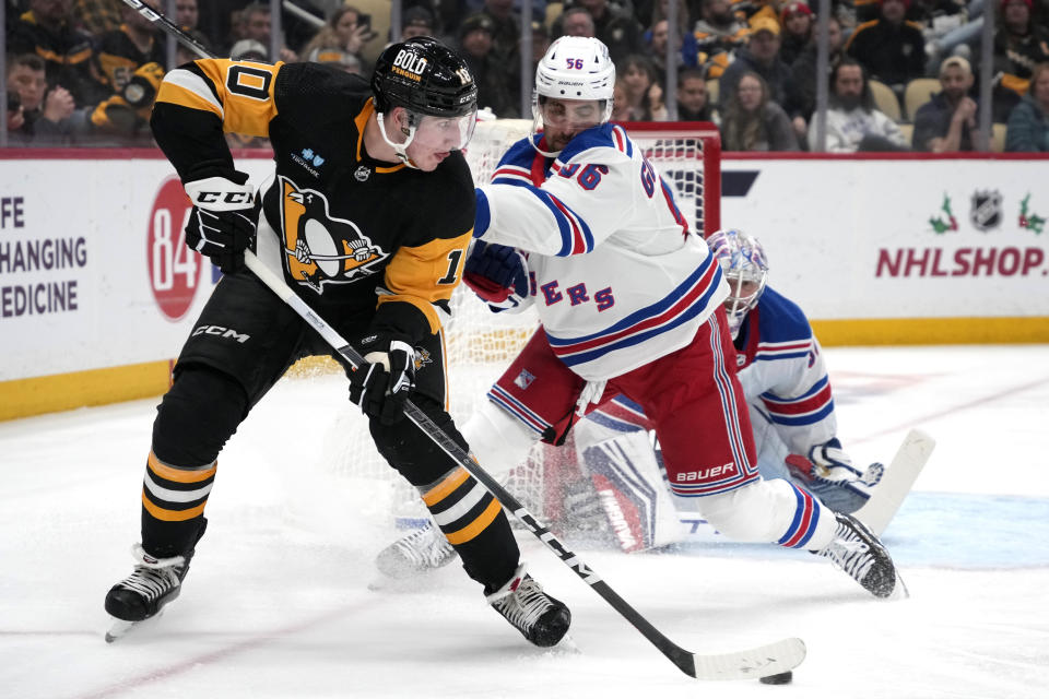 Pittsburgh Penguins' Drew O'Connor looks to make a pass with New York Rangers' Erik Gustafsson defending during the second period of an NHL hockey game in Pittsburgh, Wednesday, Nov. 22, 2023. (AP Photo/Gene J. Puskar)