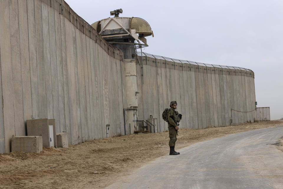 An Israeli soldier stands guard during a ceremony marking the completion of an enhanced security barrier along the Israel-Gaza border, Tuesday, Dec. 7, 2021. Israel has announced the completion of the enhanced security barrier around the Gaza Strip designed to prevent militants from sneaking into the country. (AP Photo/Tsafrir Abayov)