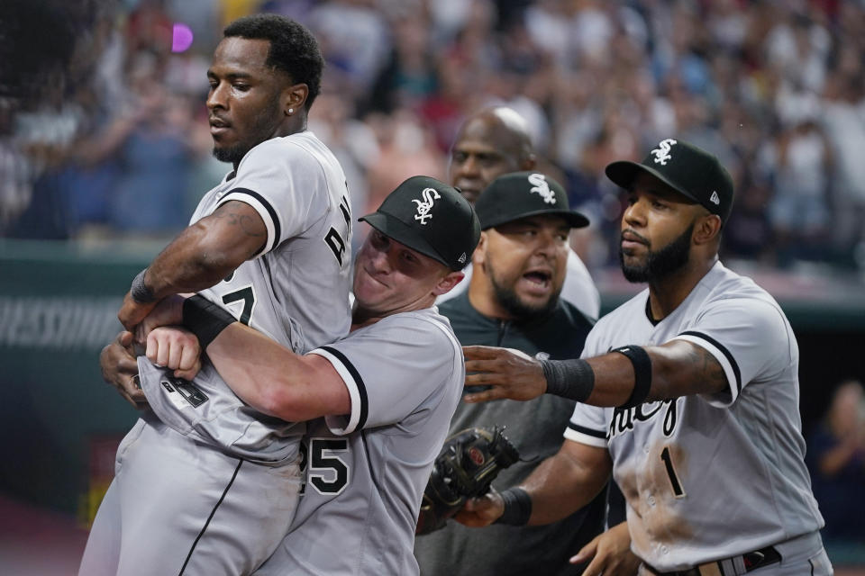 Chicago White Sox's Tim Anderson (7) is held by Andrew Vaughn, center, after Anderson's fight with Cleveland Guardians' Jose Ramírez during the sixth inning of a baseball game Saturday, Aug. 5, 2023, in Cleveland. Elvis Andrus is at right. (AP Photo/Sue Ogrocki)