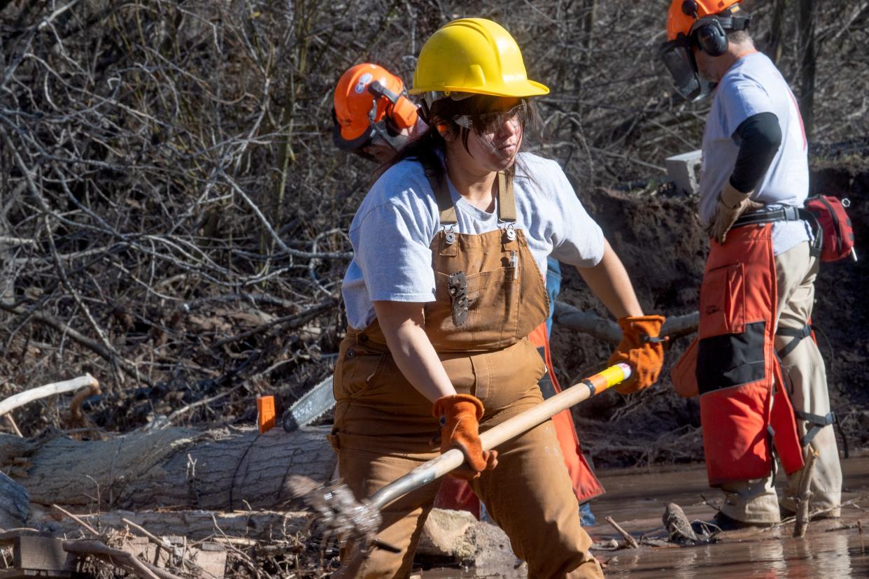 Kathy Torres Szabo, of nonprofit Team Rubicon, digs out sediment from a creek running through an Oak View property on Jan. 25. Recent storms caused debris to clog drainage channels and redirected parts of the Ventura River through residential properties.