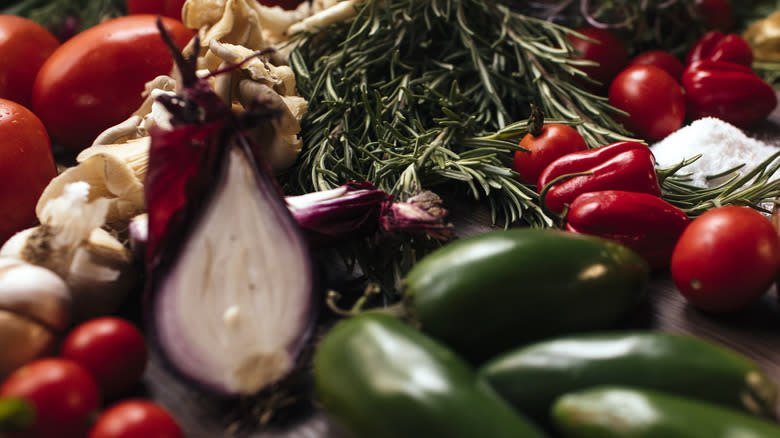 a pile of peppers garlic onions and rosemary