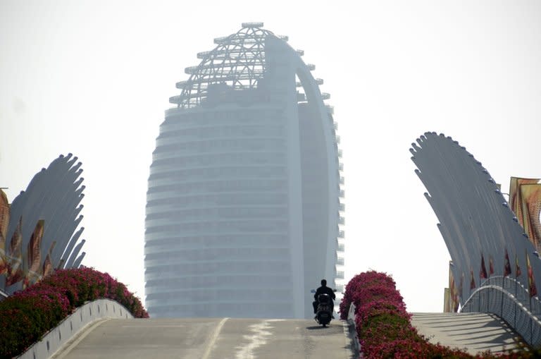 Luxury apartments of the Phoenix Island complex loom in the distance, on January 19, 2013, on China's southern Hainan province. It was billed as China's Dubai: a cluster of sail-shaped skyscrapers on a man-made island surrounded by tropical sea