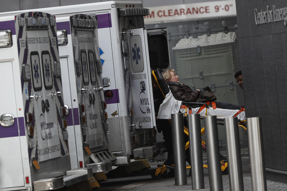 FILE - In this March 16, 2020 file photo, medical professionals bring a patient into the NYU Langone Hospital Emergency room entrance in New York. On Friday, Oct. 8, 2021, The Associated Press reported on stories circulating online incorrectly claiming New York hospitals, including NYU Langone Health, will not release newborn babies or infants in neonatal intensive care units to parents who have not been vaccinated. (AP Photo/John Minchillo)