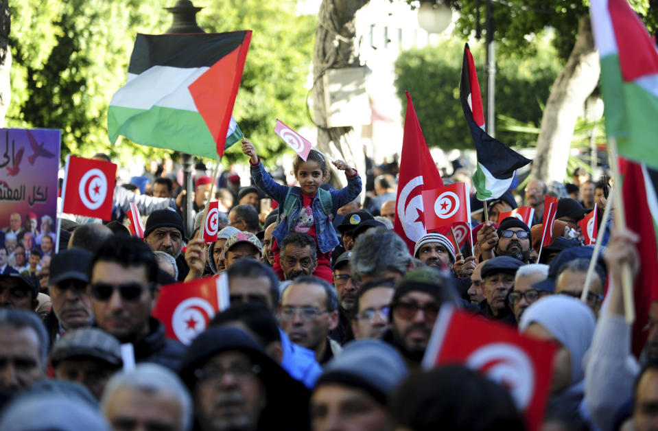 People commemorate the 13th anniversary of the Tunisian uprising in Tunis, Sunday, Jan. 14, 2024. (AP Photo/Hassene Dridi)