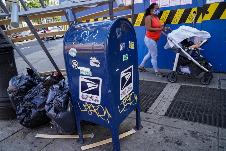 Pedestrians pass a USPS mailbox on Fulton Street in the Brooklyn borough of New York, Monday, Aug. 17, 2020.