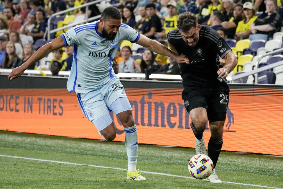 Nashville SC defender Taylor Washington, right, moves the ball past CF MontrÈal defender George Campbell, left, during the second half of an MLS soccer match Saturday, May 4, 2024, in Nashville, Tenn. Nashville won 4-1. (AP Photo/George Walker IV)