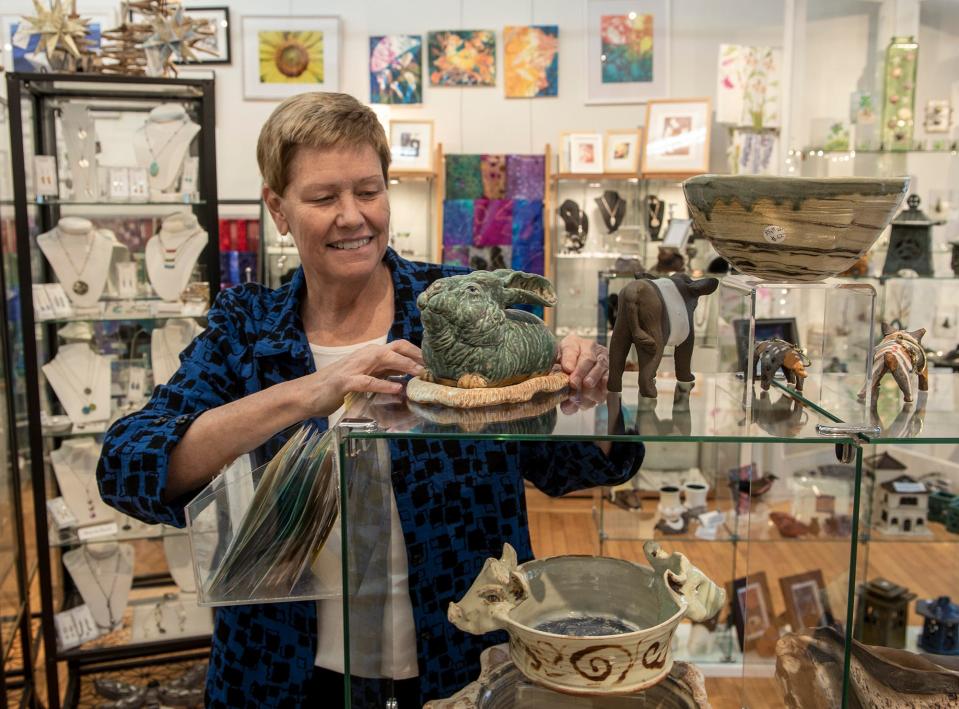 At Five Crows Gallery & Handcrafted Gifts in Natick, Sherry Anderson shows off pottery and functional sculptures by Robin Henschel, Nov. 25, 2022. The rabbit sculpture is a butter dish.