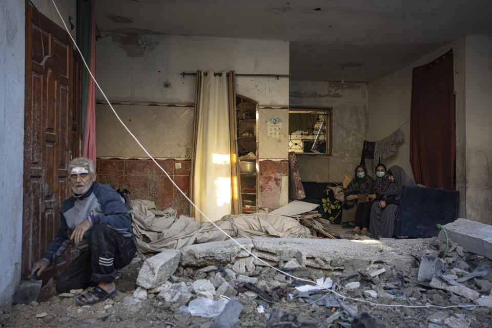 Palestinians look at the destruction after an Israeli strike in Rafah, southern Gaza Strip, Friday, Dec. 29, 2023. (AP Photo/Fatima Shbair)