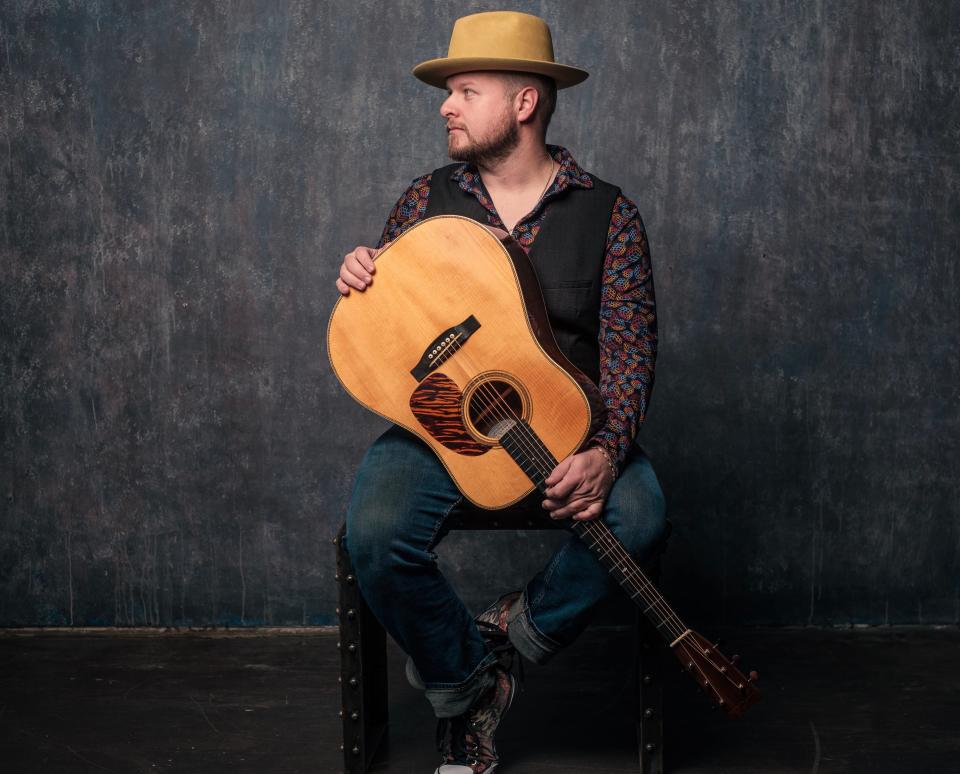 Bluegrass musician Rick Faris poses with his custom-made acoustic guitar. He will be inducted Saturday into the Kansas Music Hall of Fame.