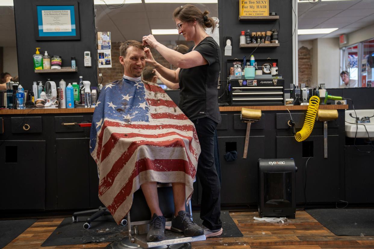 Kylie Brookes, right, cuts Josh Cobb’s hair at Beards & Shears Barber Shop in downtown Hope, Arkansas.