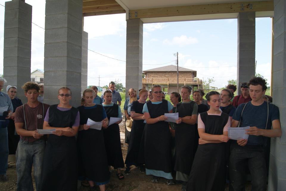 Amish and other volunteers sing "No, Not One" during a dedication ceremony Wednesday, June 1, 2022, for a house they bulit for Hurricane Ida victims in Dulac.