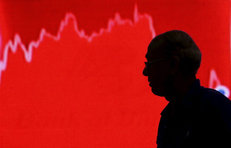 A man looks at a screen displaying news of markets update inside the Bombay Stock Exchange (BSE) building in Mumbai