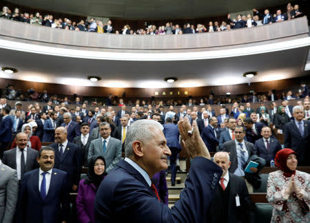 Turkey's Prime Minister Binali Yildirim greets members of parliament from his ruling AK Party (AKP) as he arrives for a meeting at the Turkish parliament in Ankara, Turkey, April 18, 2017. REUTERS/Umit Bektas
