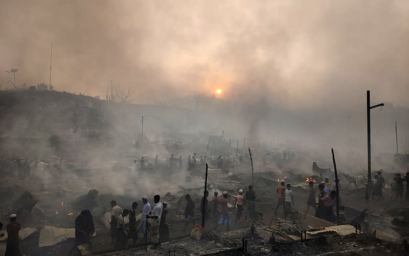 Rohingya refugees try to salvage their belongings after a major fire in their Balukhali camp